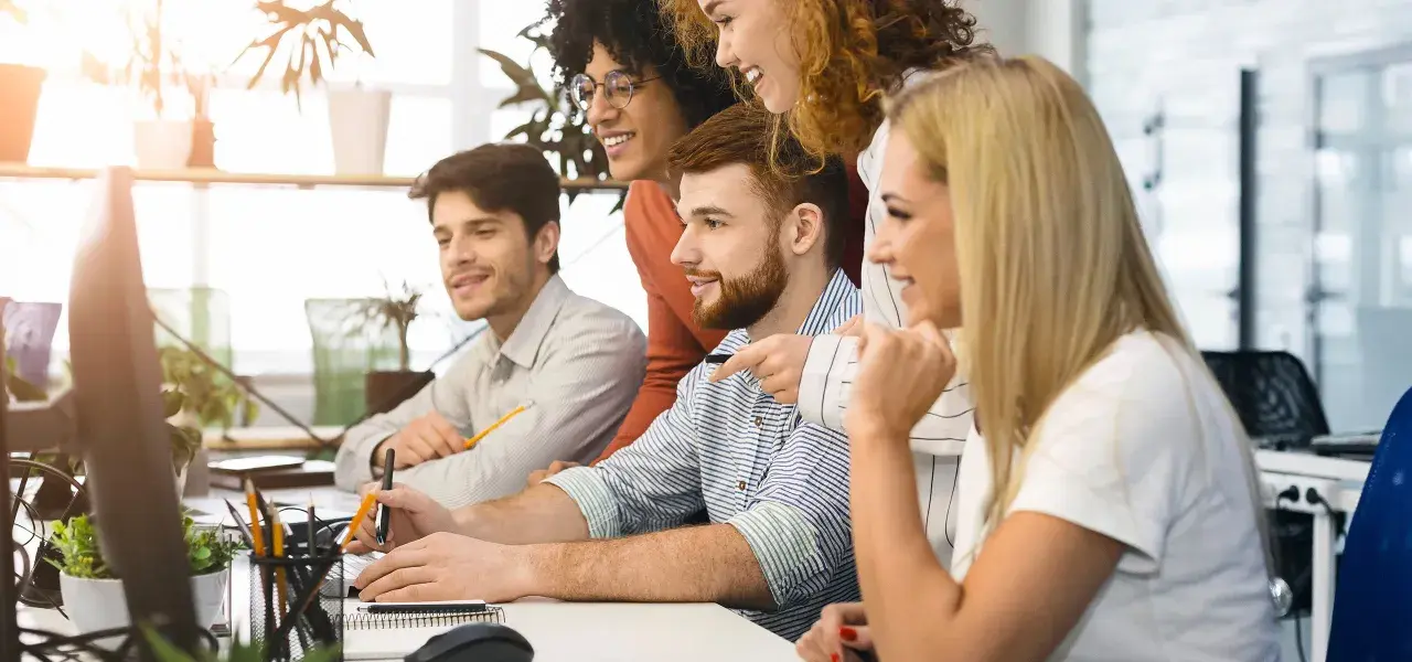 Zespół dyskutuje o nowych trendach w marketingu, analizując dane na komputerach.