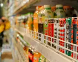 Rząd puszek z napojami energetycznymi na półce sklepowej, część branży FMCG.