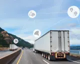 Ciężarówki na drodze z ikonami symbolizującymi telematykę: lokalizację, sygnał Wi-Fi, opłaty drogowe i wsparcie 24/7.