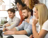 Zespół dyskutuje o nowych trendach w marketingu, analizując dane na komputerach.