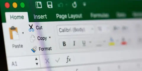Ekran Excela z widocznym menu "Home" i opcjami "Cut", "Copy", "Paste". Dowiedz się, jak zablokować formułę w Excelu.