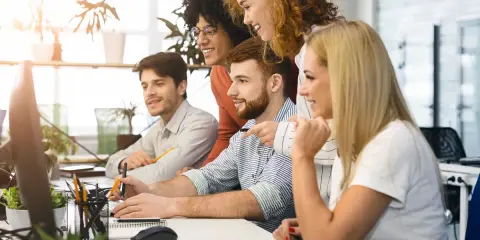 Zespół dyskutuje o nowych trendach w marketingu, analizując dane na komputerach.