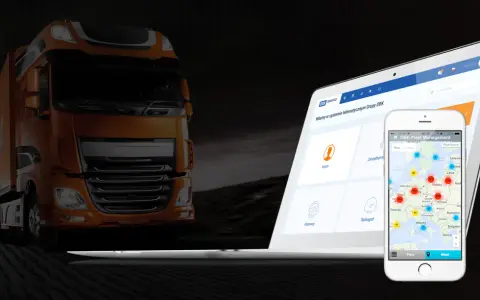 Pomarańczowa ciężarówka obok laptopa i telefonu z mapą pokazującą lokalizację pojazdów dzięki systemowi GPS.