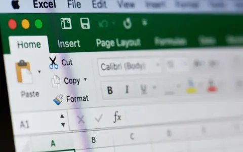 Ekran Excela z widocznym menu "Home" i opcjami "Cut", "Copy", "Paste". Dowiedz się, jak zablokować formułę w Excelu.