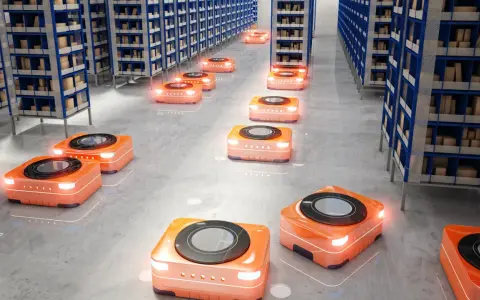 Pomarańczowe roboty autonomiczne poruszają się między rzędami regałów w nowoczesnych magazynach, usprawniając logistykę.