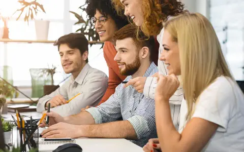 Zespół dyskutuje o nowych trendach w marketingu, analizując dane na komputerach.