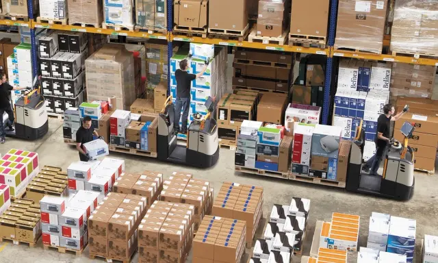 Magazynierzy w akcji, kompletacja jednostopniowa zamówień. Wózki widłowe i palety z elektroniką.