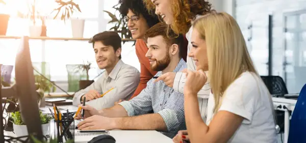 Zespół dyskutuje o nowych trendach w marketingu, analizując dane na komputerach.